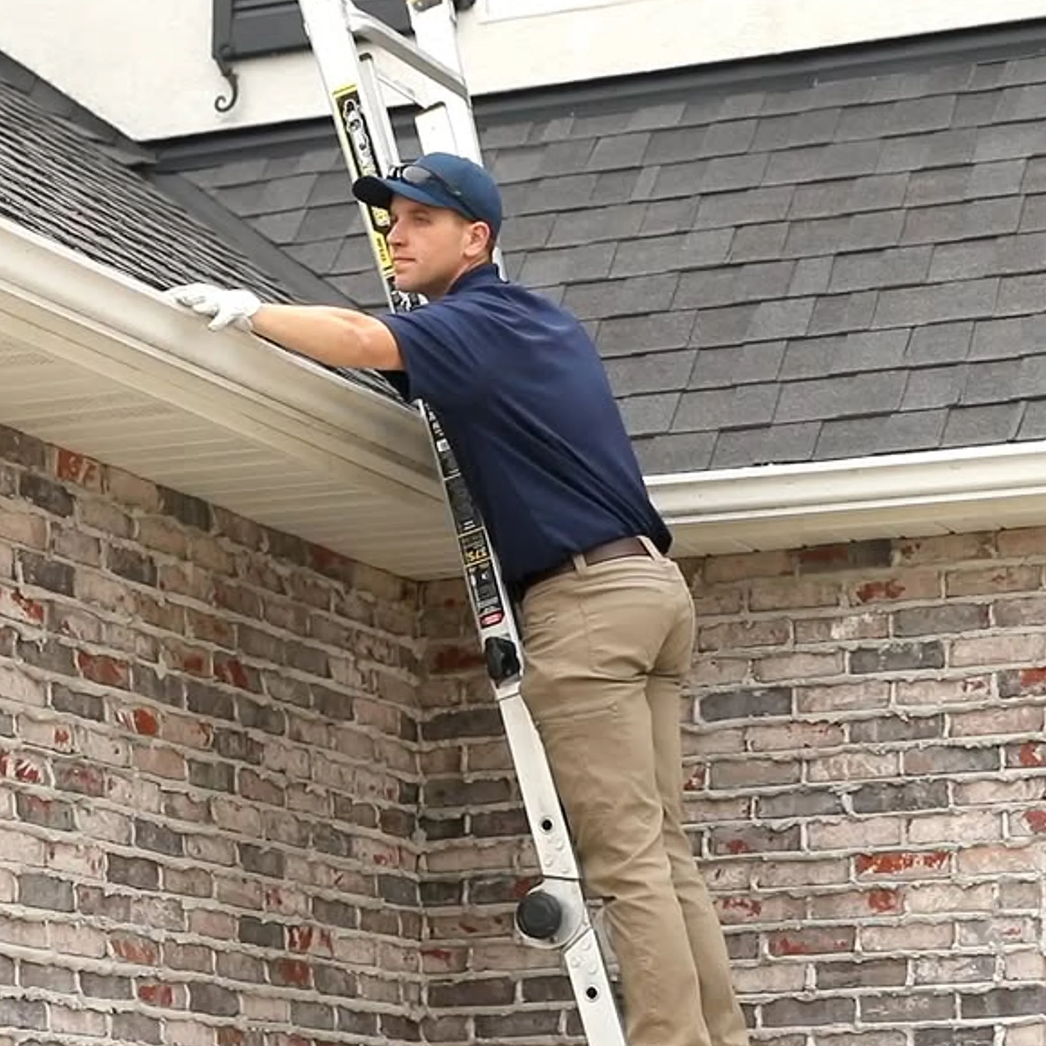 person cleaning house gutters outdoors
